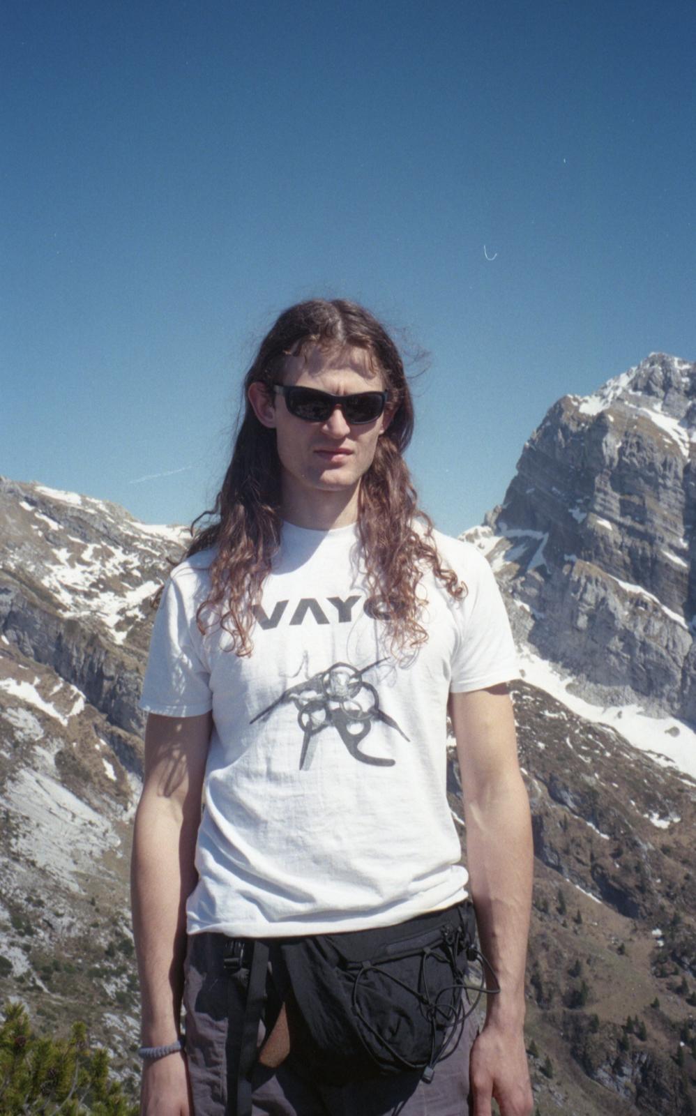 Climber in a VAYO t-shirt in front of snow-capped peaks