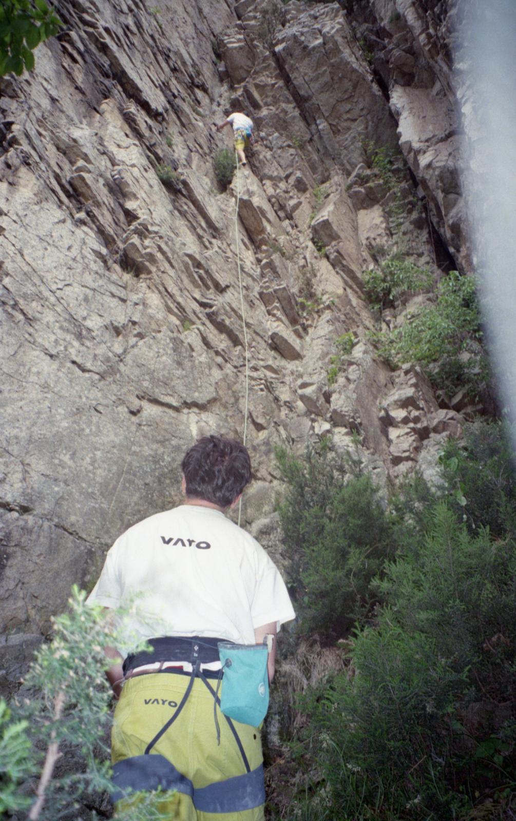 Climber in VAYO gear looking up at a partner on a rock face